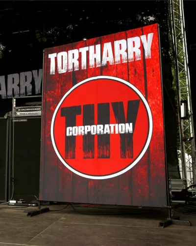 Large red roll-up banner with the Tortharry band logo set up on a music stage